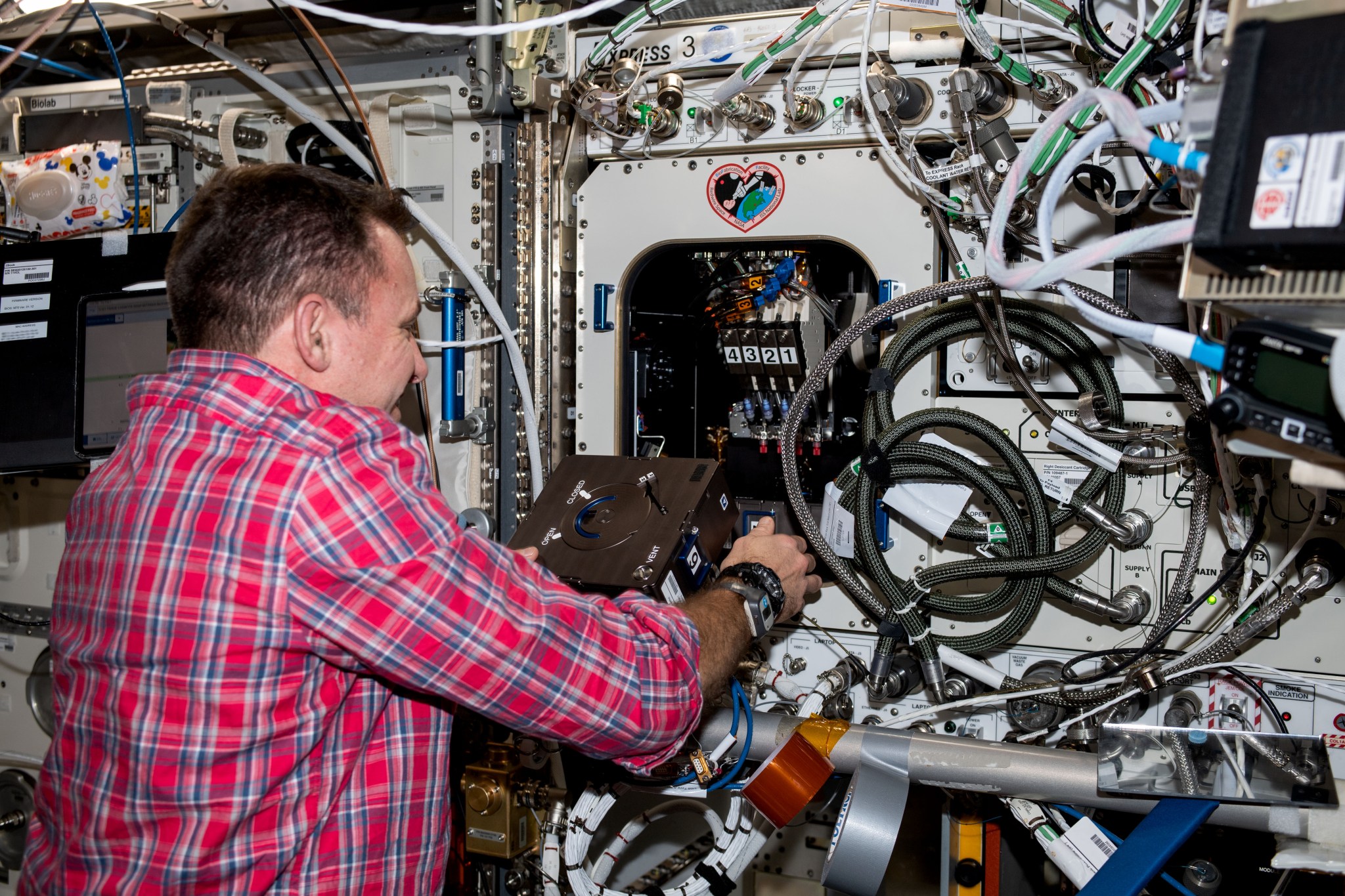 imagen de un astronauta instalando el hardware del experimento