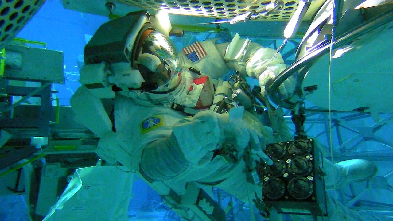 astronaut in full space suit in pool running tests 