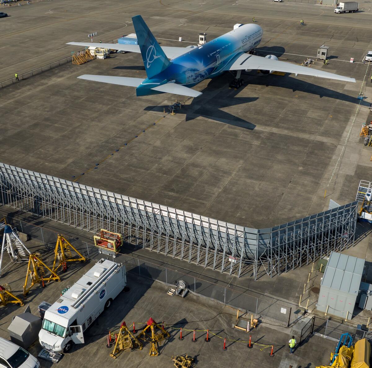 The Boeing ecoDemonstrator 777-200 WB212, sits on the test section at Paine Field while the NASA Langley Mobile Laboratory parks behind the blast wall.