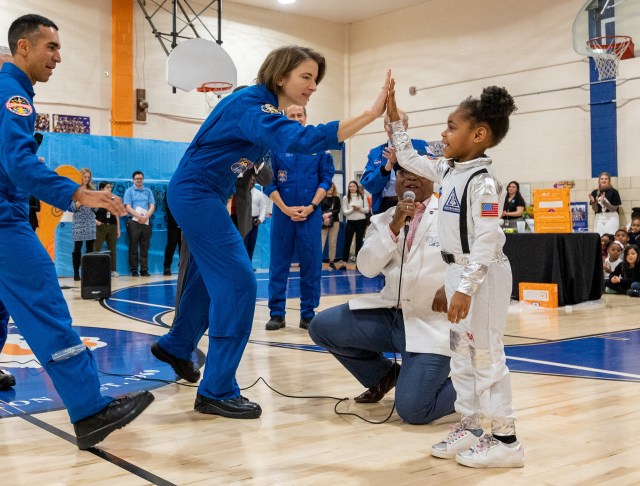 Photo of NASA astronauts with students in a school gymnasium