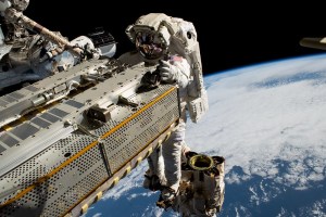 Spacewalker Woody Hoburg rides tha Canadarm2 robotic arm.