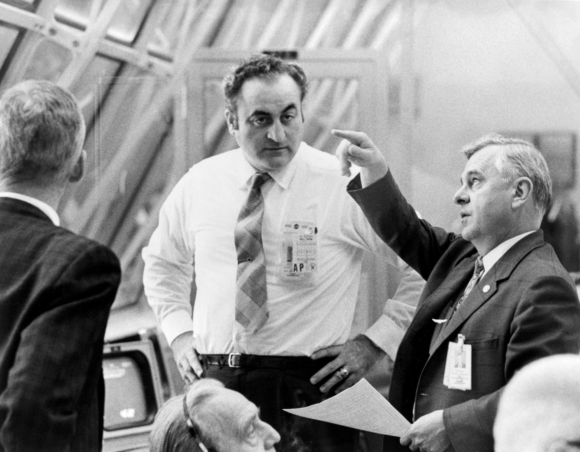 Rocco Petrone listens to Walter Kapryan at the Launch Control Center at KSC.