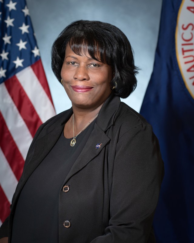Portrait of Yvette Hariis, with U.S. and NASA flags in background.