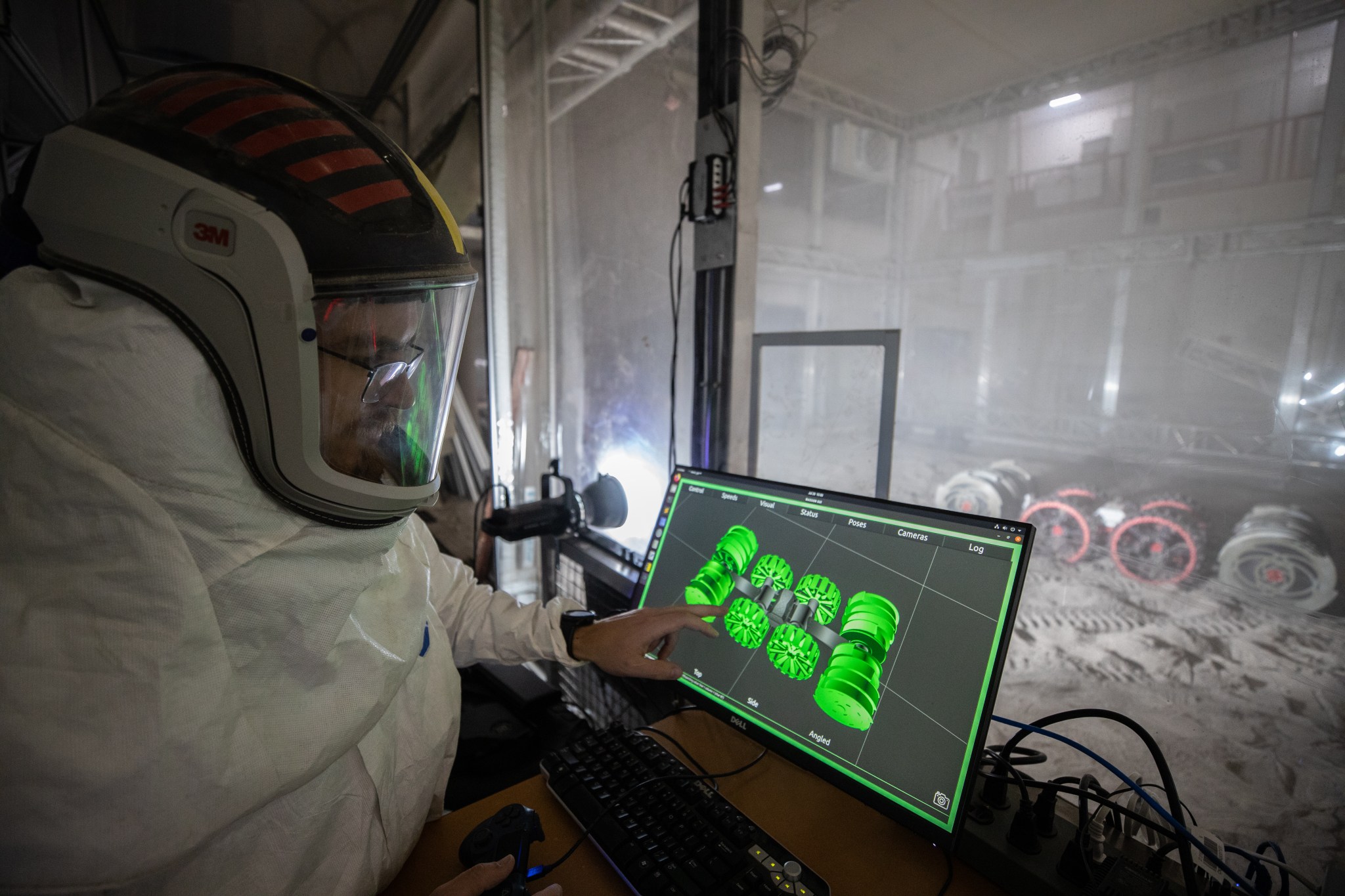 A team from the Granular Mechanics and Regolith Operations Lab operates a test of the ISRU Pilot Excavator (IPEx) breadboard unit, also known as RASSOR, in regolith bin inside Swamp Works.