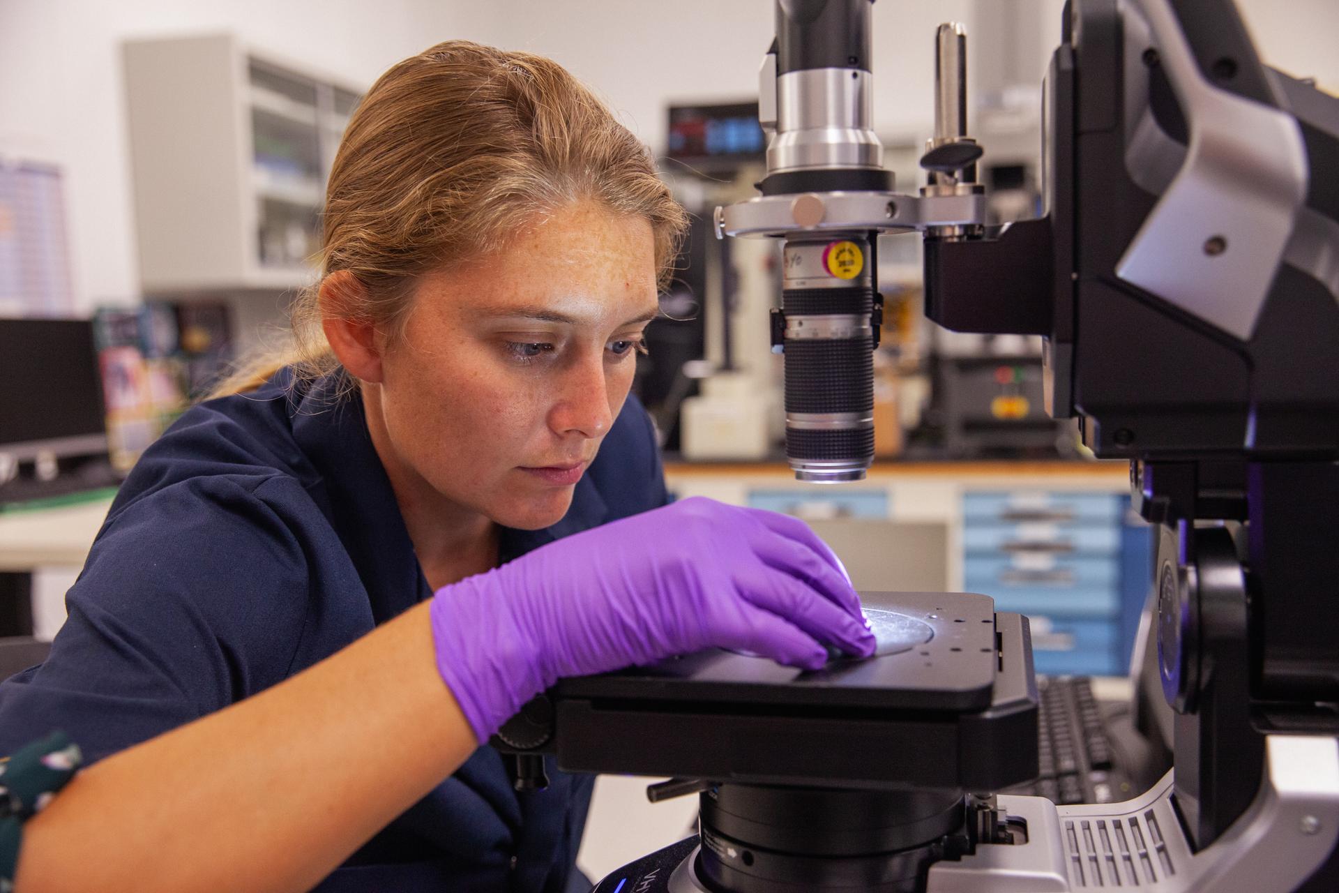 NASA engineer examples a sample placed on a digital microscope.