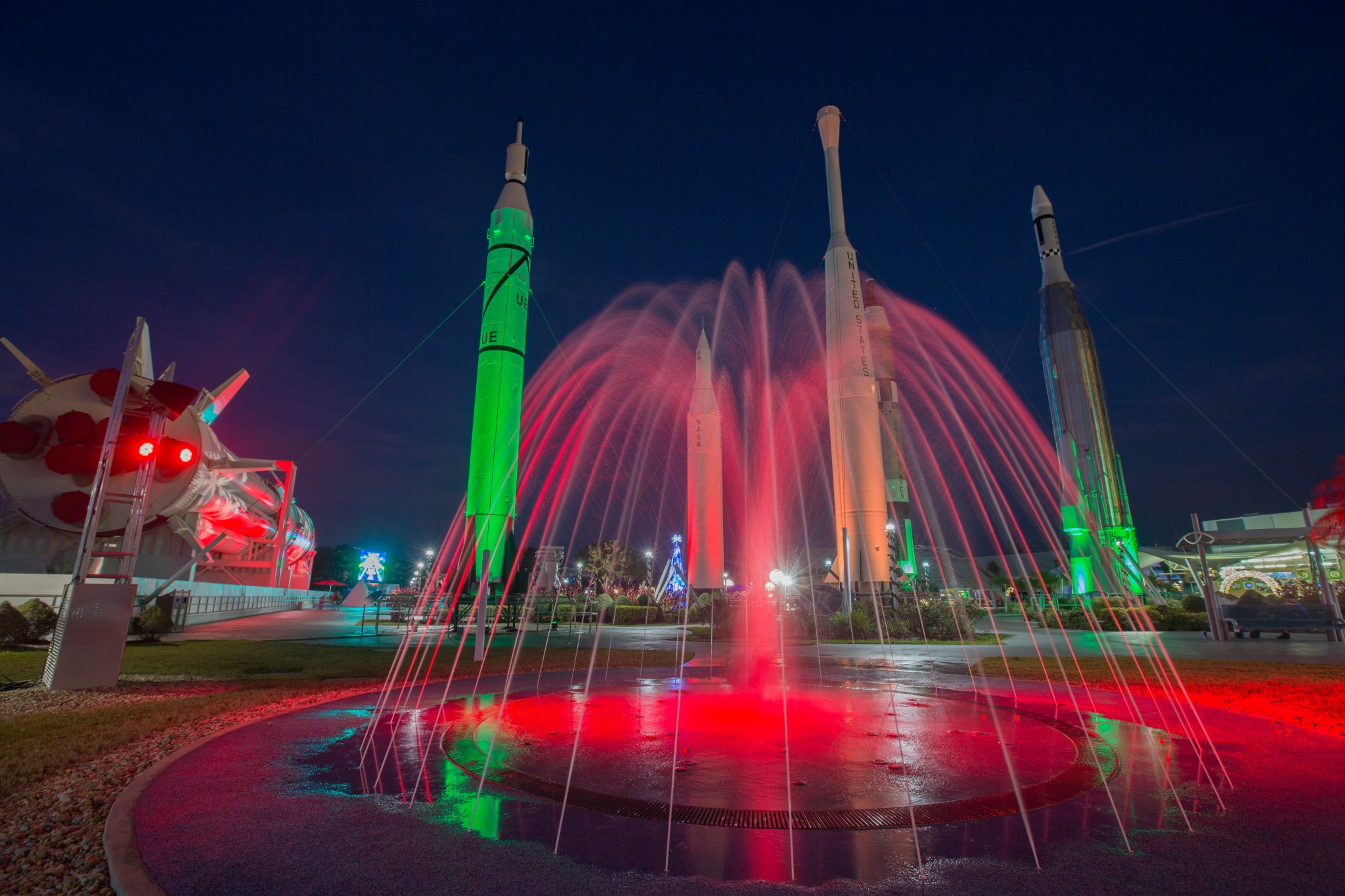 The Rocket Garden and fountain at the Kennedy Space Center Visitor Complex in Florida are lit in green and red for Holidays.