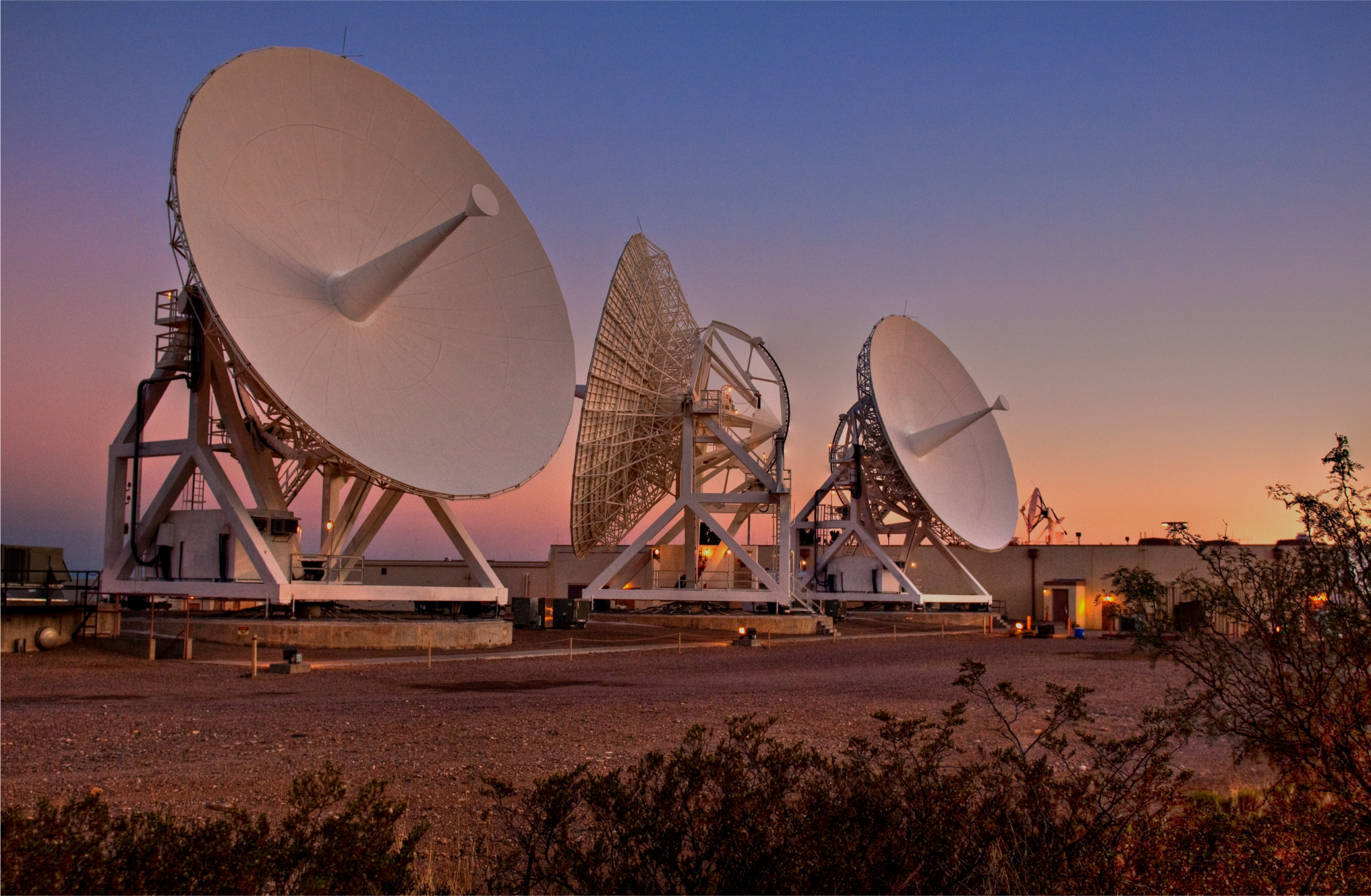 Three Near Space Network antennas can be seen in front of a rising Sun at the Second Tracking and Data Relay Satellite System (TDRSS) Ground Terminal.