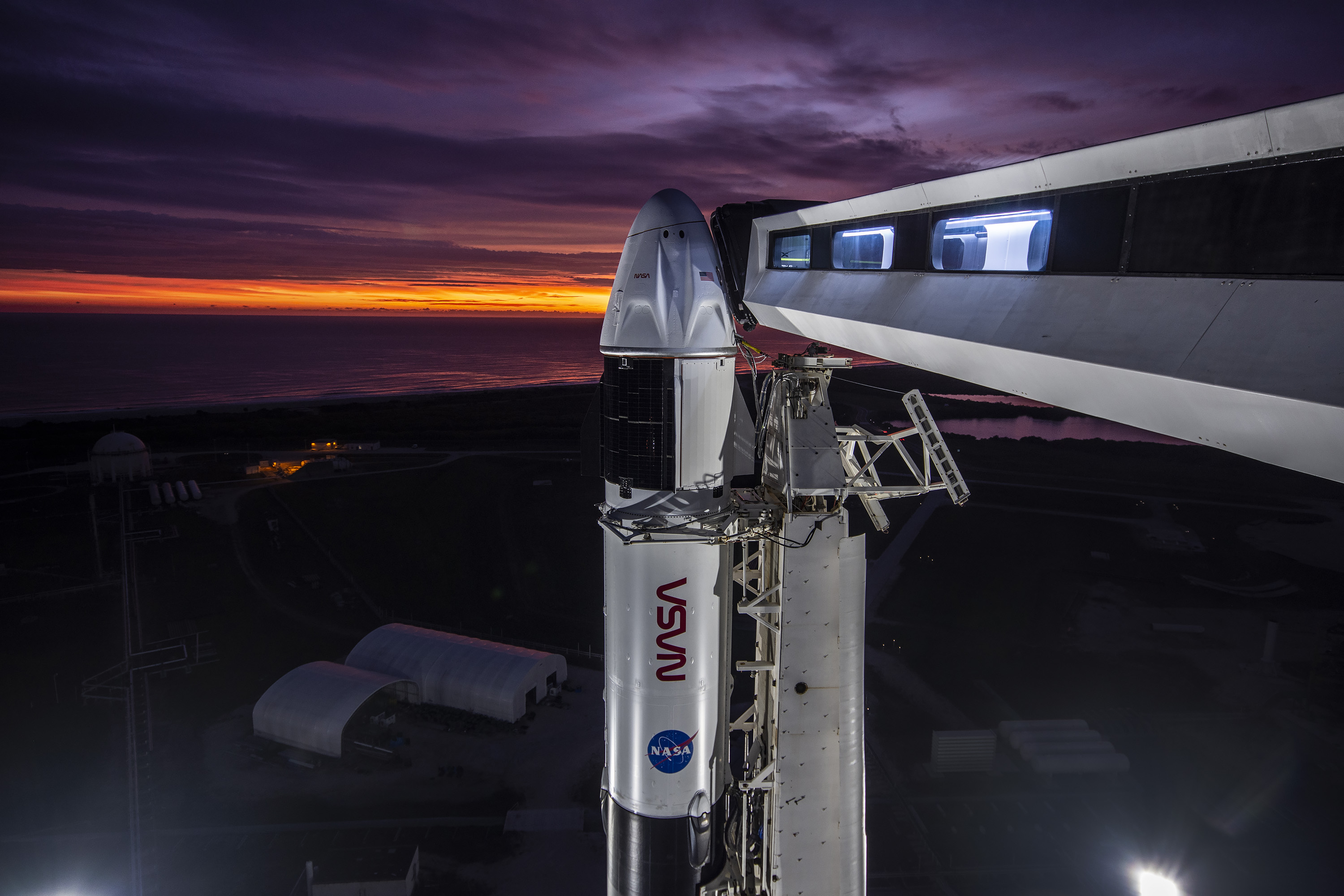 A close-up view of the SpaceX Falcon 9 rocket vertical with the Crew Dragon atop for the Crew-3 mission at Launch Pad 39A at NASA’s Kennedy Space Center in Florida during sunrise on Oct. 28, 2021. Also in view is the crew access arm.