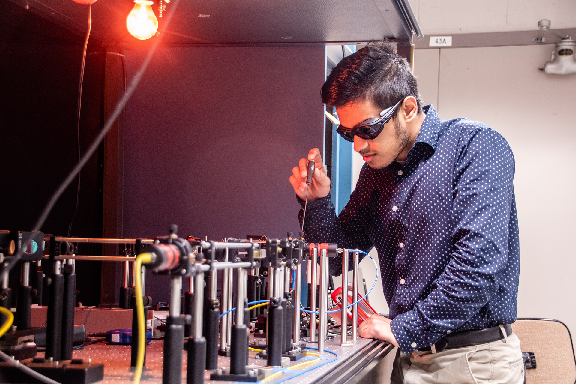 An intern tests equipment in a quantum lab.