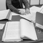 Photograph showing archival documents and the hands of Ames Senior Archivist April Gage as she works to preserve them.