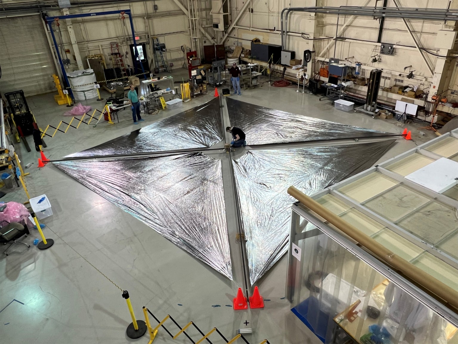 Advanced Composite Solar Sail System’s solar sail is laid out on the floor of a warehouse