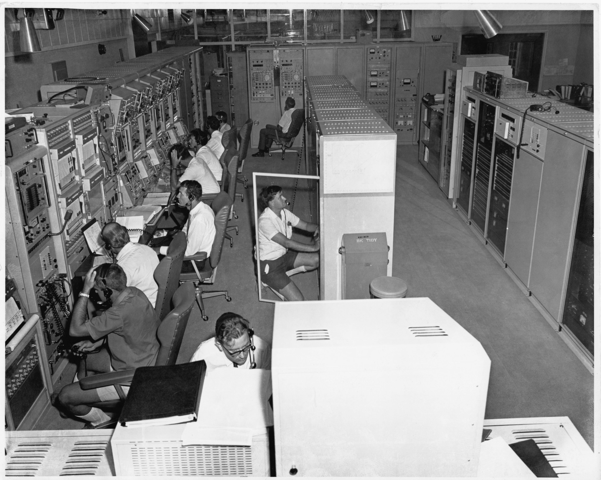 A black and white photo of Australian technicians operating and monitoring systems for the 26-meter (85-foot) antenna at the Tidbinbilla Deep Space Instrumentation Facility (now known as the Canberra Deep Space Communications Complex) in January 1969.