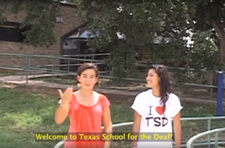 Two girls perform sign language