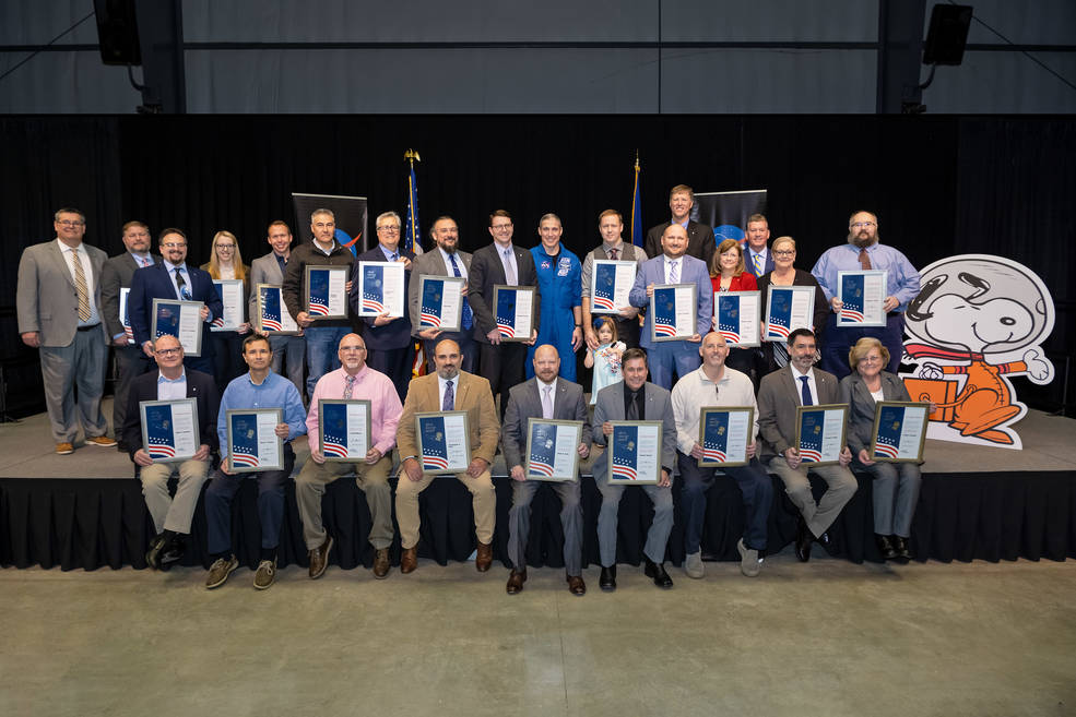2023 Silver Snoopy Award recipients take a group photo with astronaut Michael Hopkins (center).