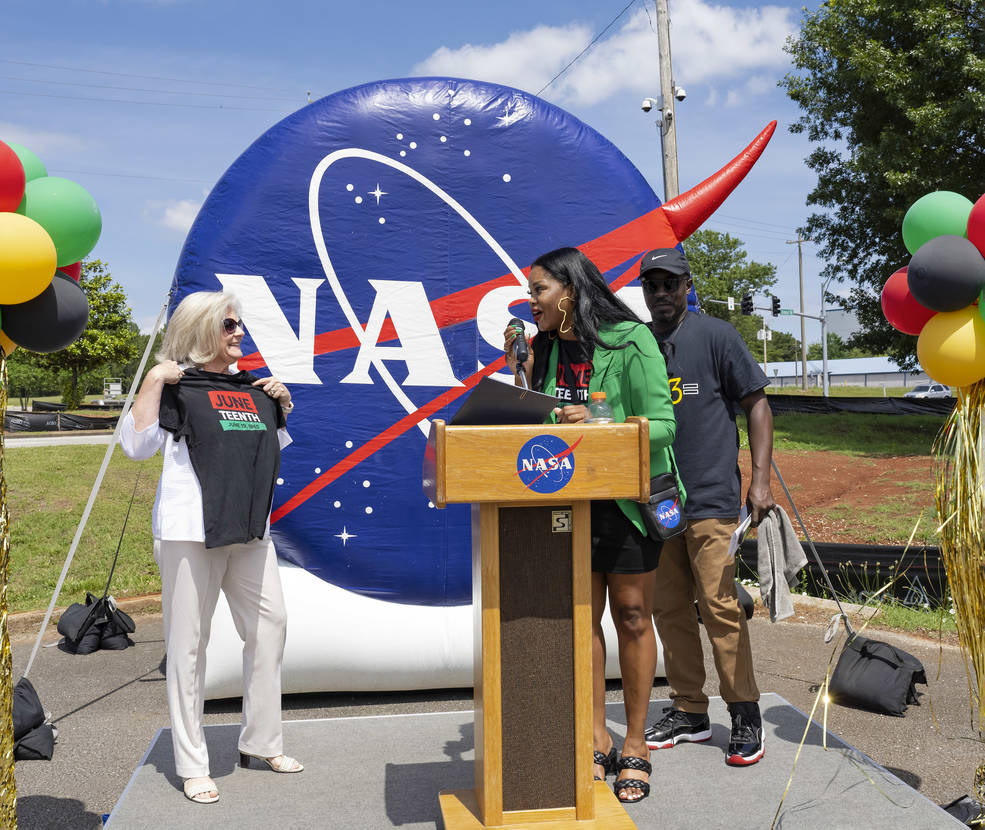 Amanda Otieno, center, and Black Employees u0026amp; Nick Benjamin, right, present Jody Singer, left, with a T-shirt at Marshall’s Juneteenth celebration last summer.