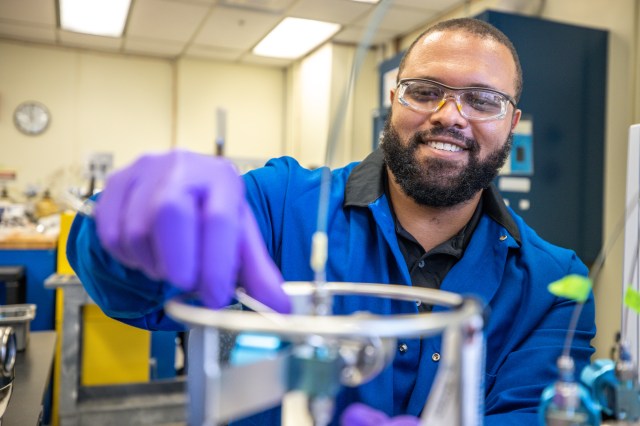 Chemist Trey Barnes smiling in front of a chemistry sample