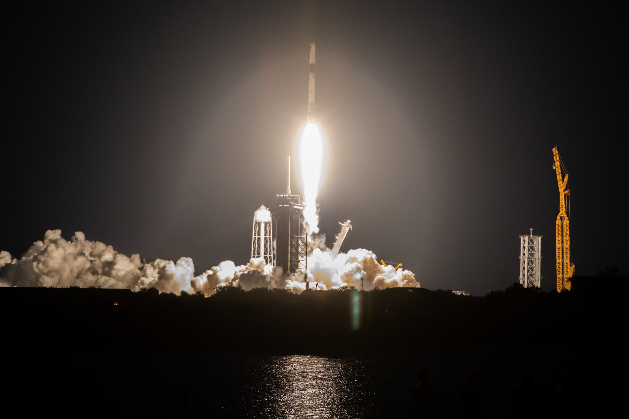 A SpaceX Falcon 9 rocket and Dragon spacecraft lifts off at night from the launchpad at NASA's Kennedy Space Center in Florida. 