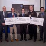 Five men hold three giant checks for the CubeSat Challenges