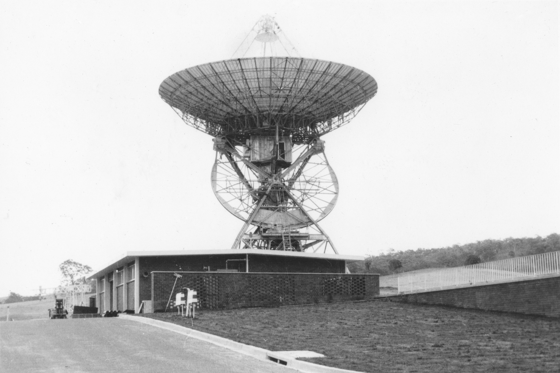 A black and white photo of a 26-meter antenna at the Tidbinbilla Deep Space Instrumentation Facility (now the Canberra Deep Space Communication Complex) in July 1969. The antenna, Deep Space Station 42, points to the sky.