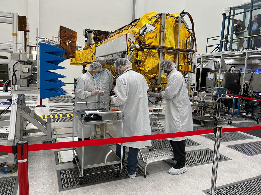 Engineers and technicians work on the science instrument payload
