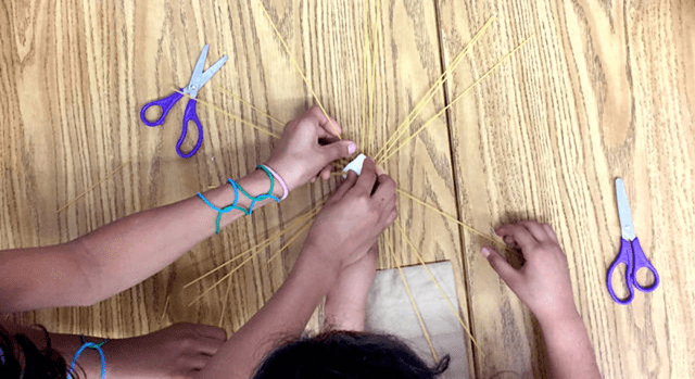 Students working on an activity using spaghetti noodles