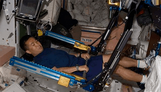 An astronaut doing resistive exercise in space