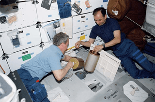 Astronauts Thomas D. Jones, mission specialist, and Mark L. Polansky, pilot, change out lithium hydroxide canisters