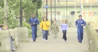 Three people jogging with two astronauts