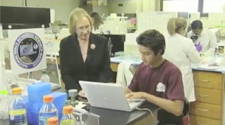 A teacher assist a student in a lab