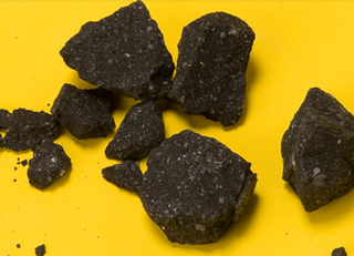 Fragmented black rocks against a yellow background