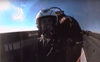 A pilot wears a g-suit in the cockpit of a jet