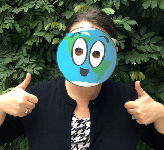 A woman wears a mask that looks like planet Earth