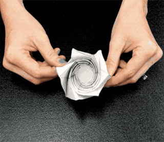Animation of hands folding and opening a carefully creased paper