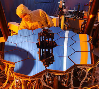 A scientist is seen working on the James Webb Space Telescope