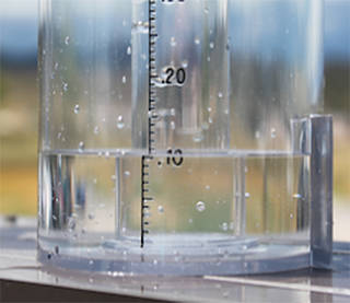 A side view of the bottom of a rain gauge with 10 mm of water in it