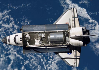 Space Shuttle Discovery, with payload doors  open, is  viewed from the ISS during rendezvous