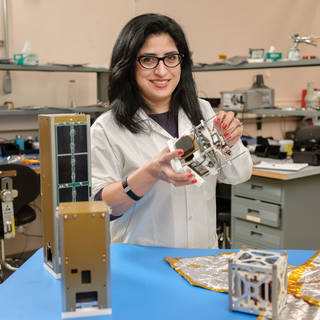 Ali Guarneros Luna holding CubeSats