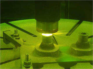 Close-up of a rocket nozzle being 3D printed with a green laser