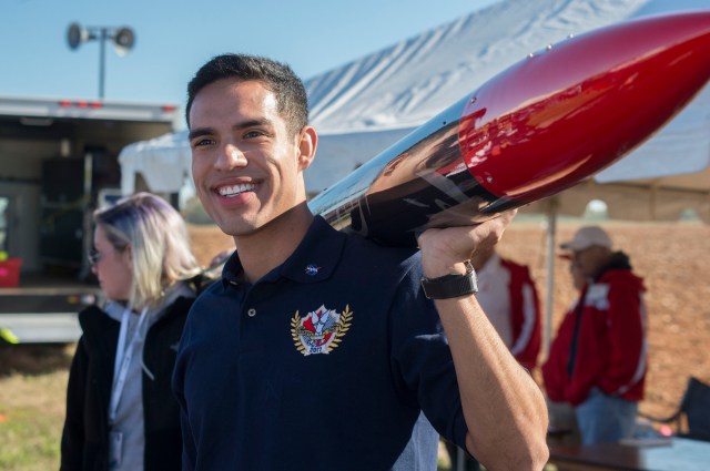 Student Launch participant smiles while holding his rocket.