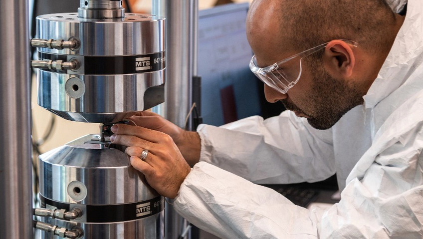 Man wearing safety glasses operates machine in lab