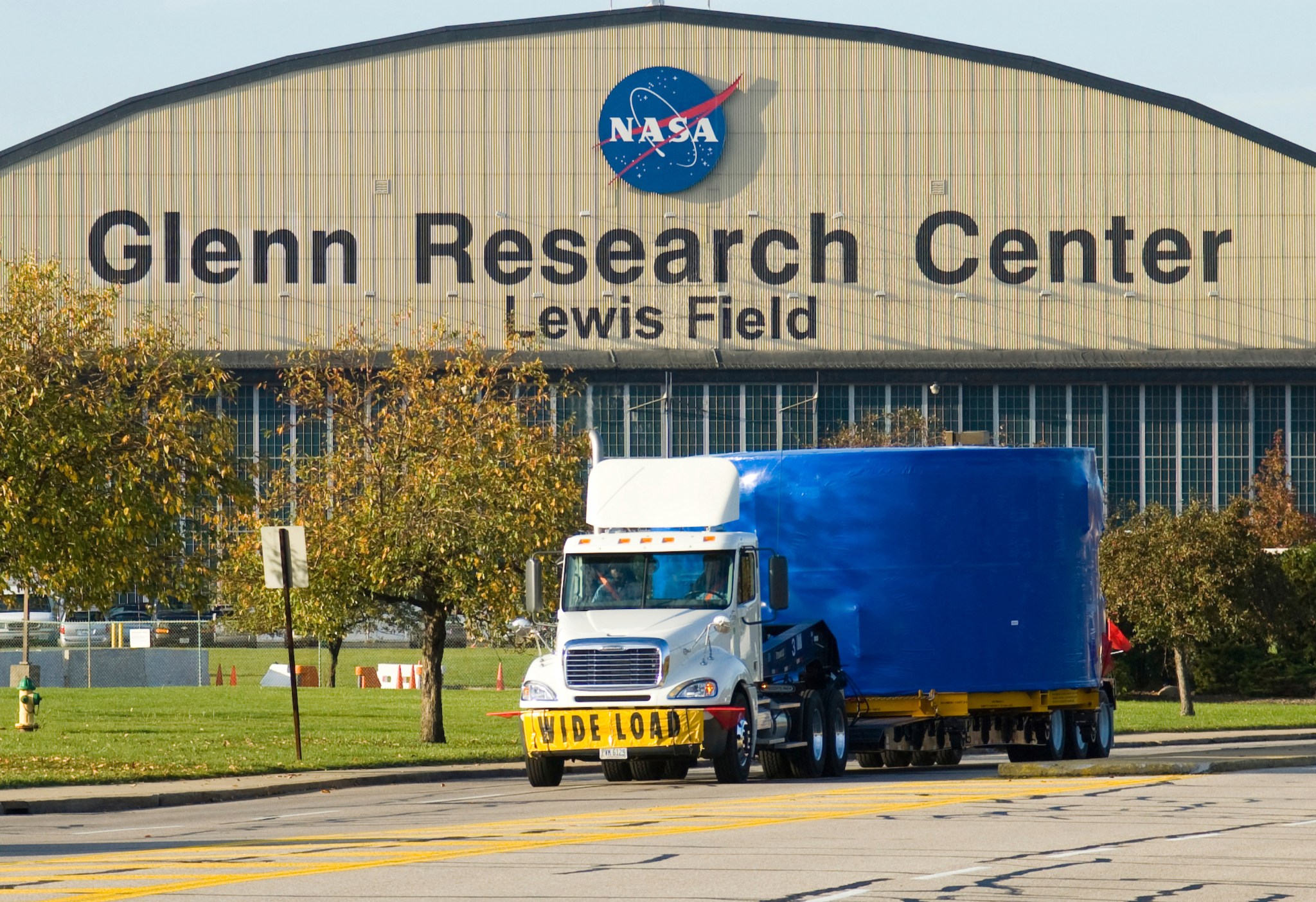 Semi truck in front of hangar.