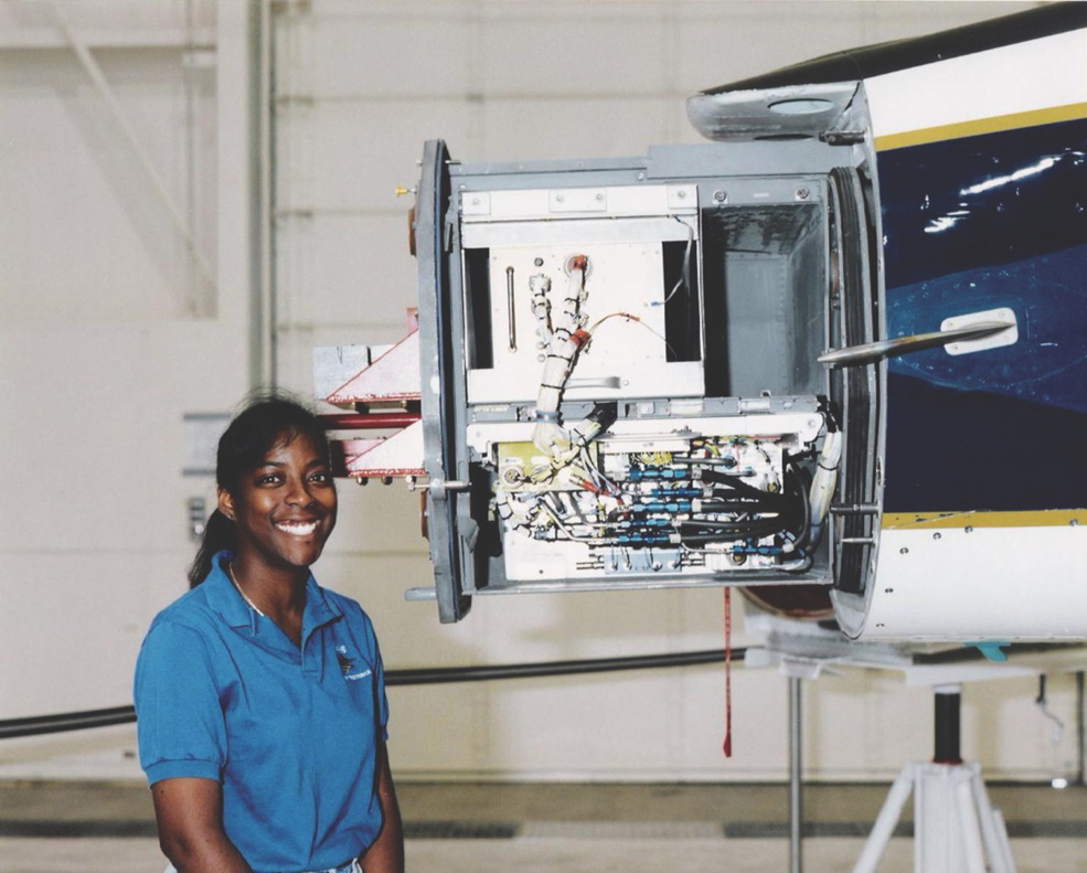 A person stands next to the front of an aircraft with exposed instrumentation.