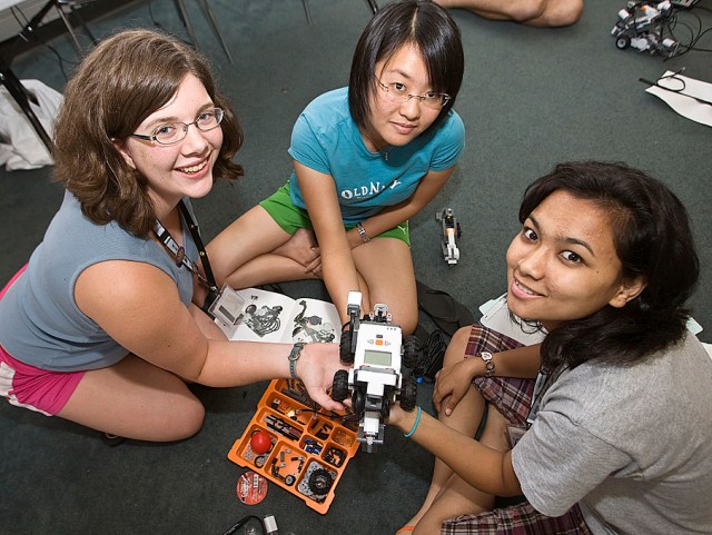 Photo of High School Aerospace Scholars students smiling with a miniature robot 