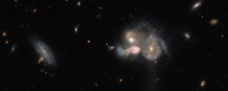 These three galaxies are set on a collision course and will eventually merge into a single larger galaxy, distorting one another’s spiral structure through mutual gravitational interaction in the process.