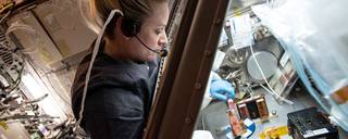 An astronaut aboard the ISS performing a science experiment.