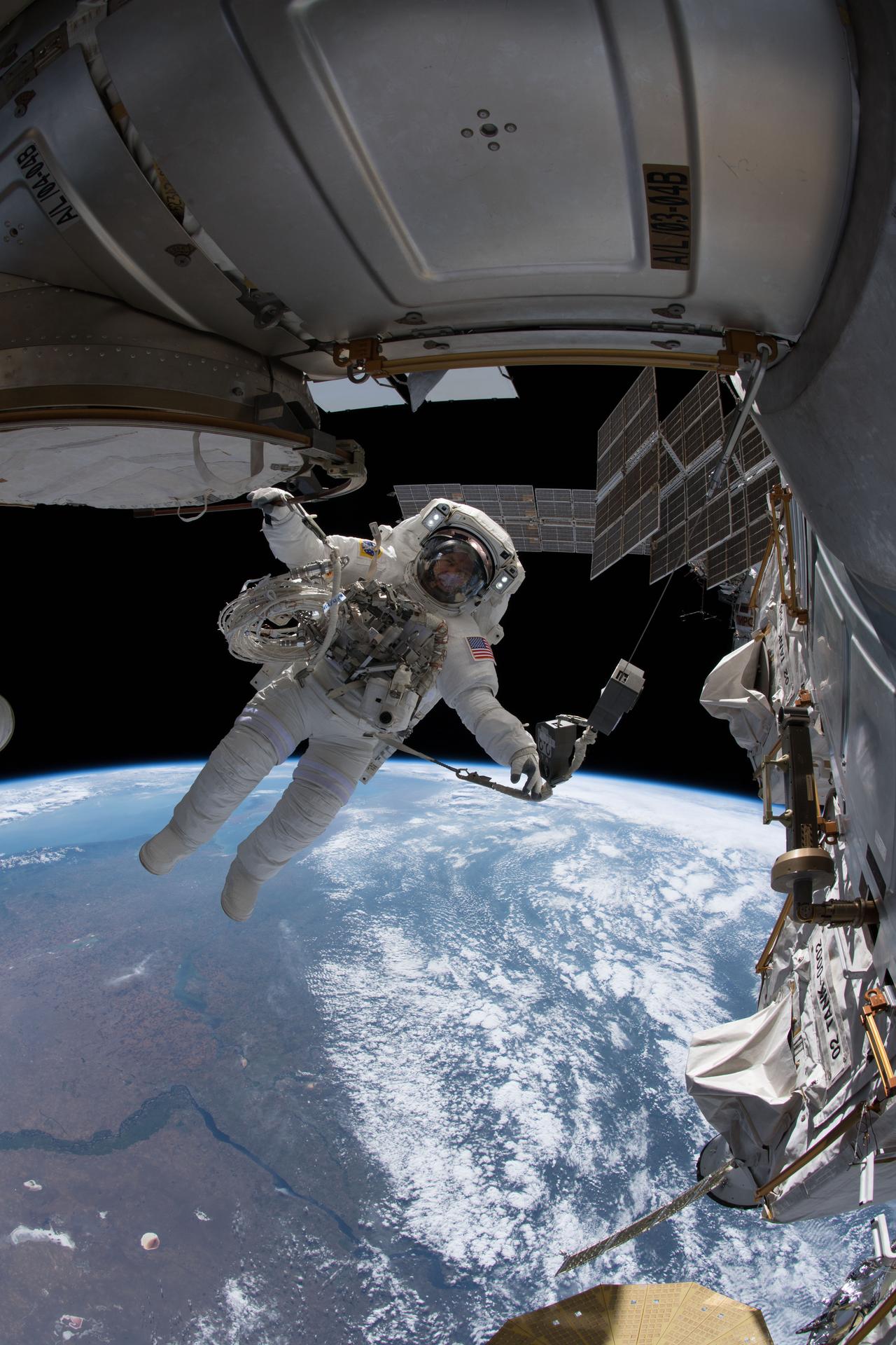 NASA astronaut Drew Feustel is pictured tethered to the International Space Station during a spacewalk.