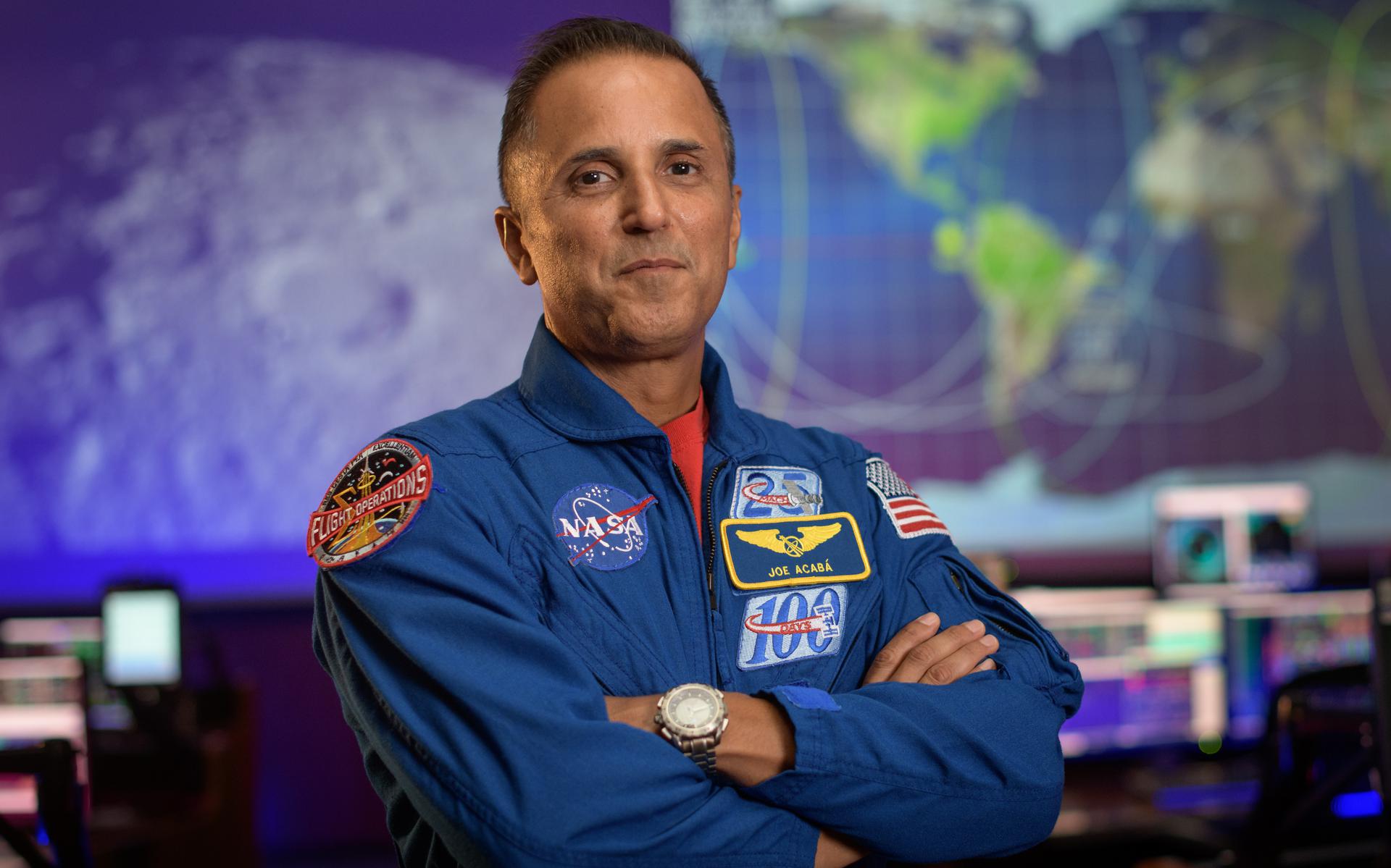 NASA astronaut Joe Acaba stands with arms crossed.