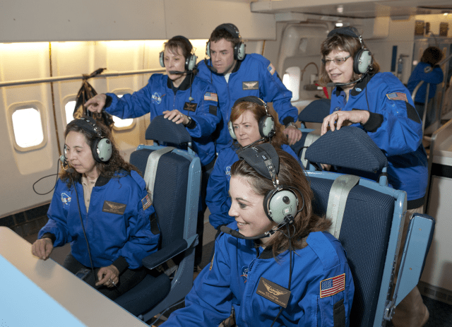 A group of educators sitting at a control panel wearing headphones
