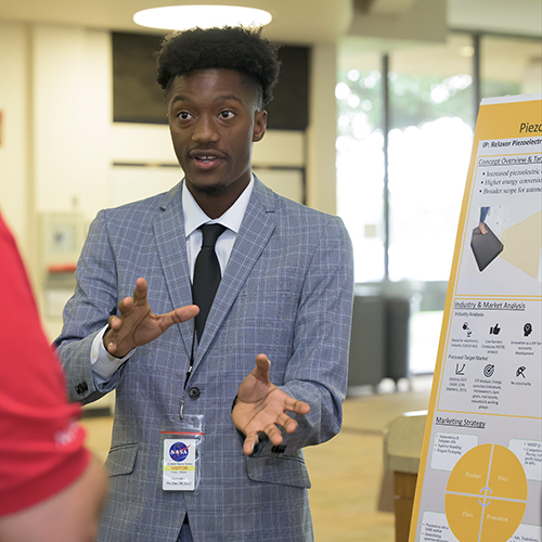 A MITTIC participant presents his team’s idea during a poster session