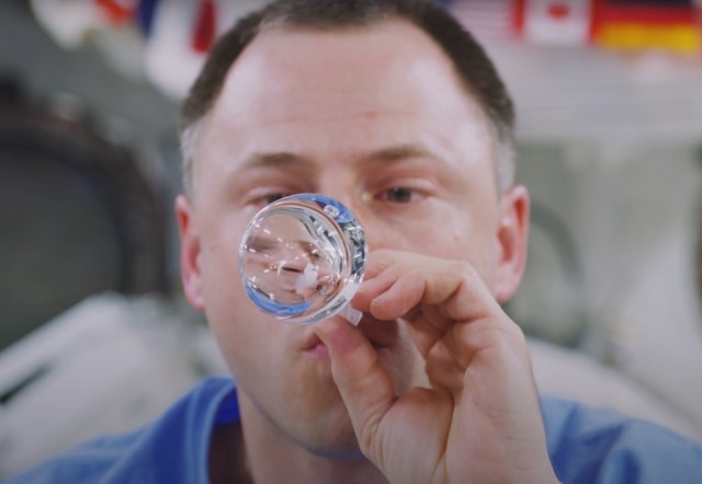 astronaut moving fluids in microgravity